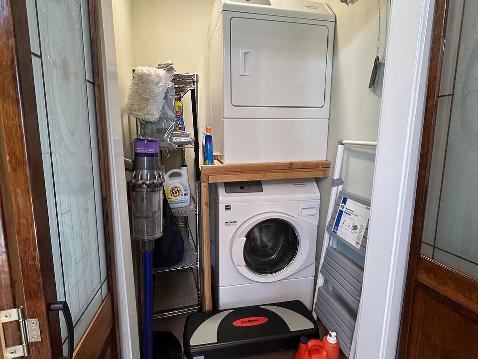 Full-sized washer and dryer behind wood and glass doors