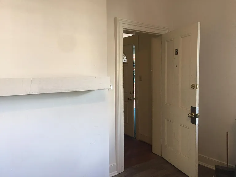 Apartment door with view to foyer and front entry. Shelf now grey to match cabinets.