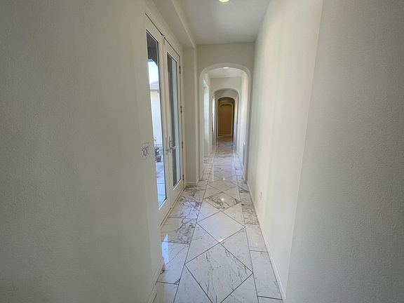 Hallway with expansive white calacatta marble floors