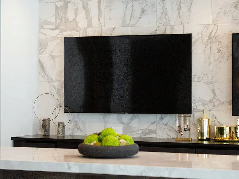 Entertainment Area Featuring Dual TVs, Display Items, and Seating Counter