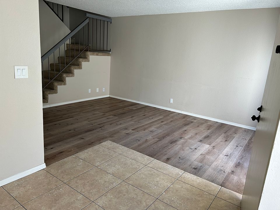 Tile entry in the foreground, towards the living room .