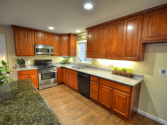 Bright kitchen with cherry cabinets, granite counters and island.