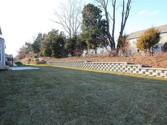 Level Rear Yard Backs Tree Line. Landscape Wall For Added Space.