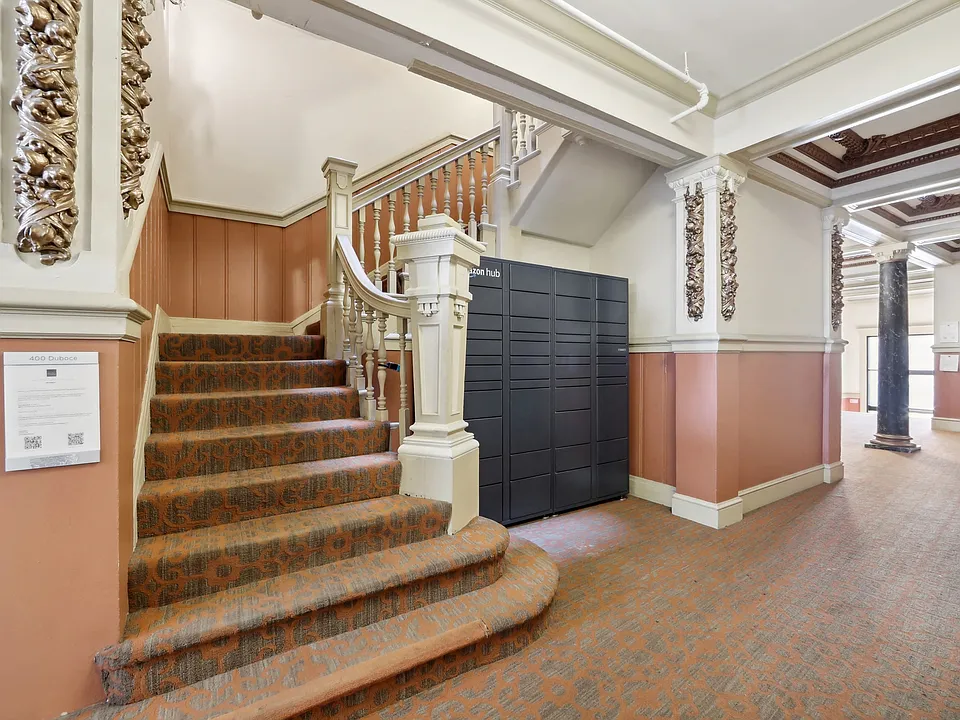 Grand hallway with a staircase adorned with a wooden railing