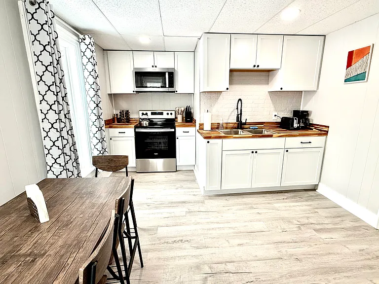The kitchen features a stainless steel range and microwave, complemented by beautiful butcher block countertops, offering both functionality and style for your cooking and meal prep needs.