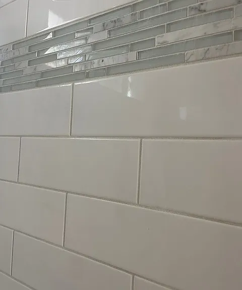 Beautiful white subway tile tub/shower with glass/marble/tile accents.
