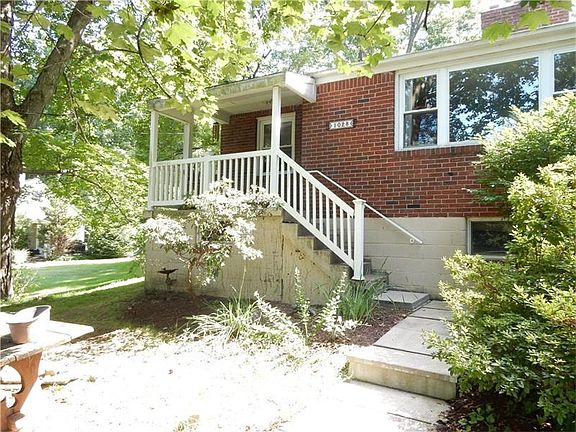 The front porch looking from the side walk. Beautiful landscaping with a lot of perennials.