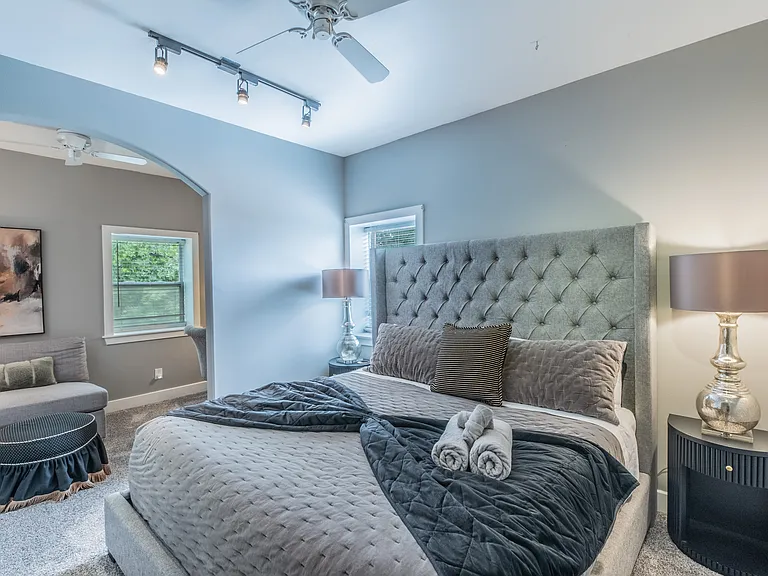 Serene master suite with a plush bed and private sitting area.