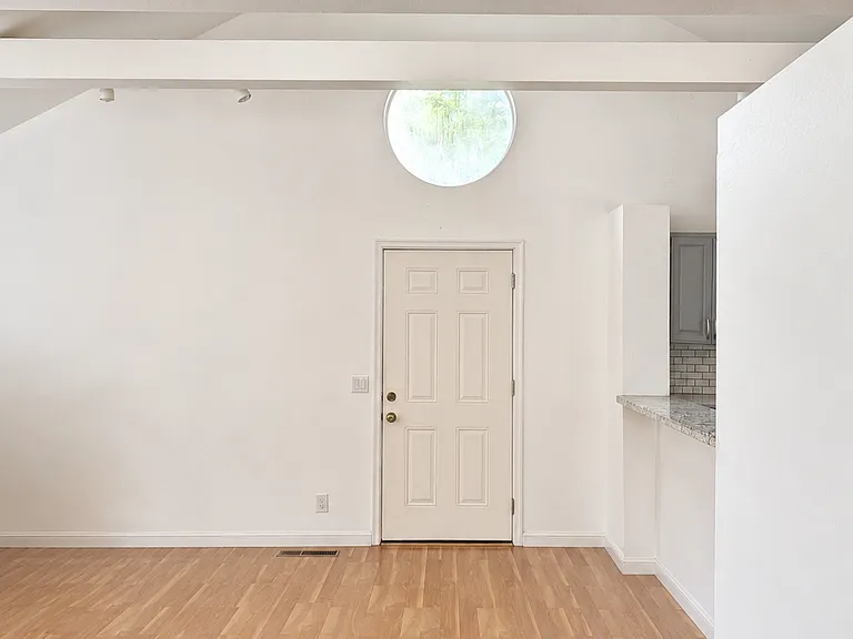 View of the front door from the hall. You can see the kitchen pass through on the right.