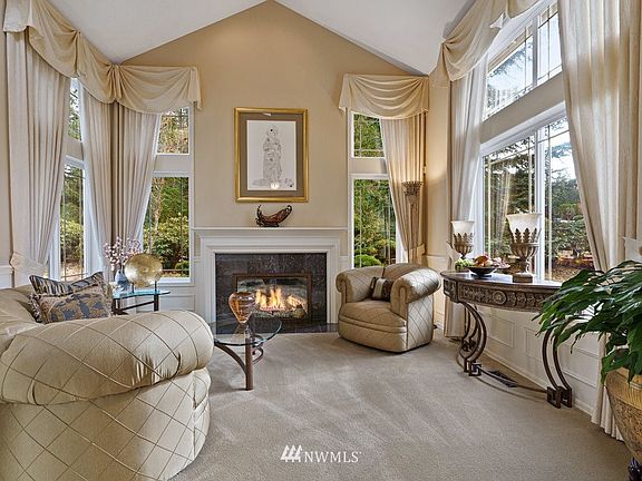 The formal living room boasts tall vaulted ceilings, wainscoting and marble surround gas fireplace. 