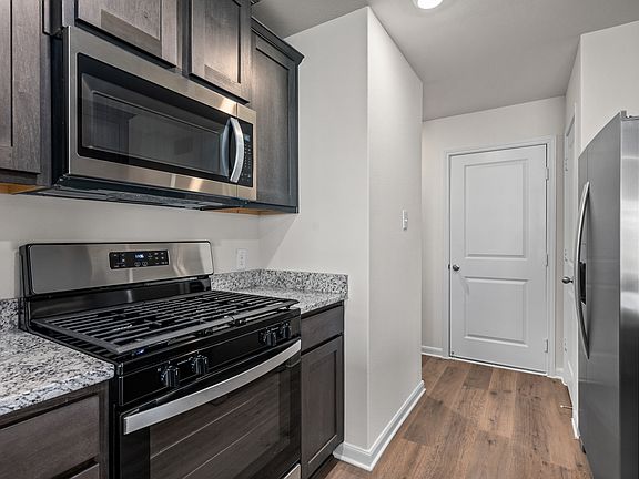 The kitchen has designer wood cabinetry.