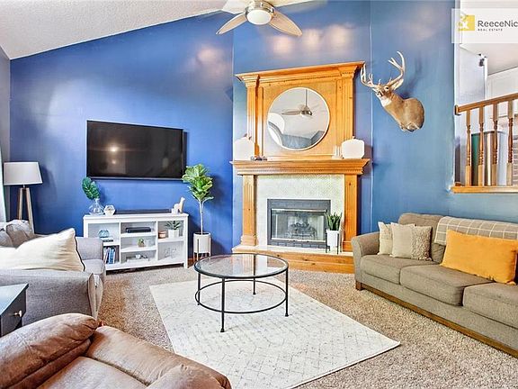 The living room with soaring ceilings and fireplace welcomes you in