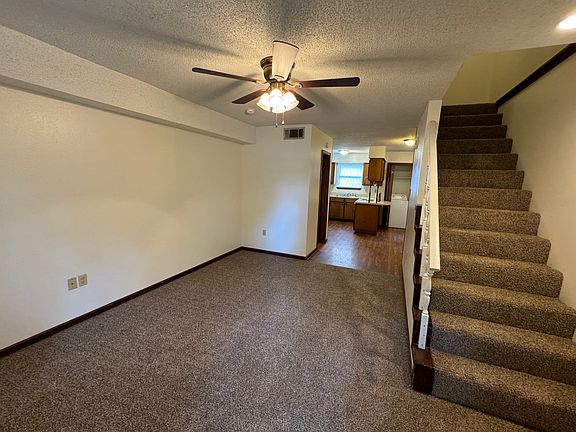Living room looking from front door toward kitchen and upstairs