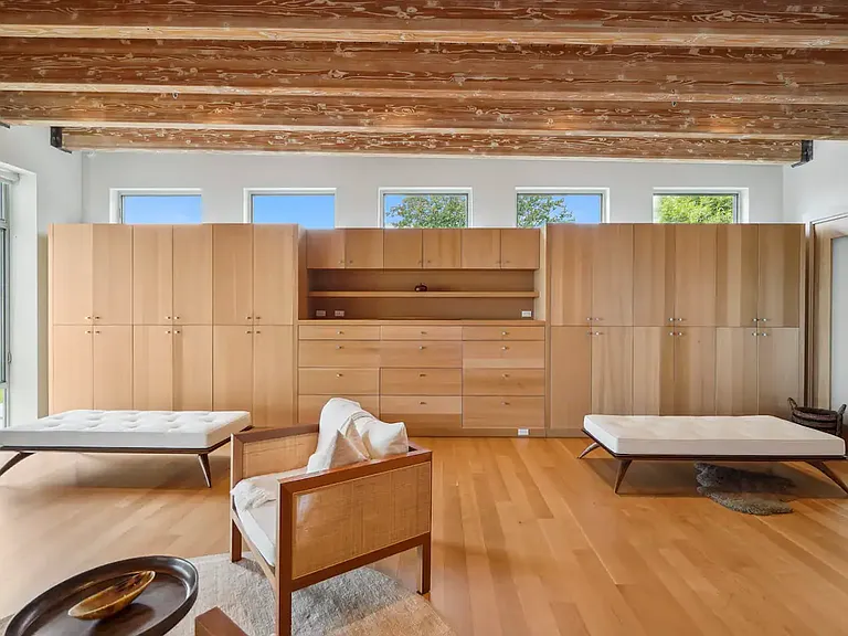 The master bedroom features custom white oak cupboards within an expansive walk-in closet area.