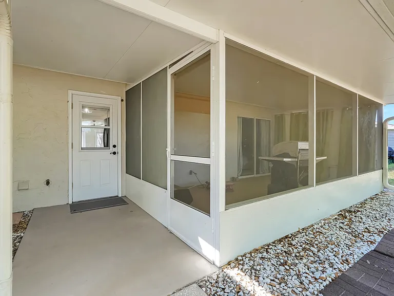 Back door providing easy access from the kitchen to the backyard, with a convenient side door connecting to the screened lanai.