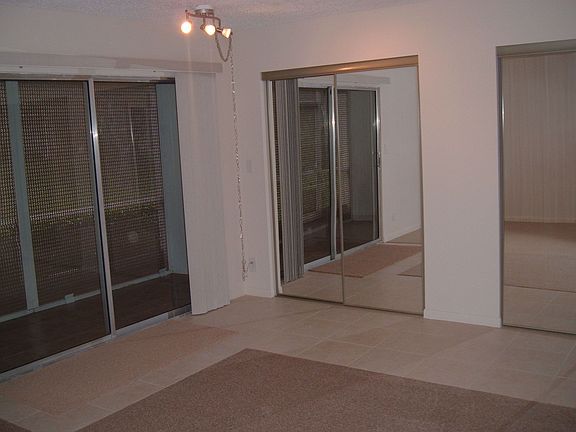 Bedroom with patio entrance & sliding mirror closet doors.