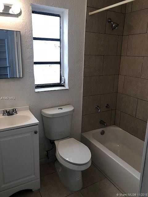Traditional tiled bath-shower including tiled floor for easy upkeep. Some units have blue tiles.