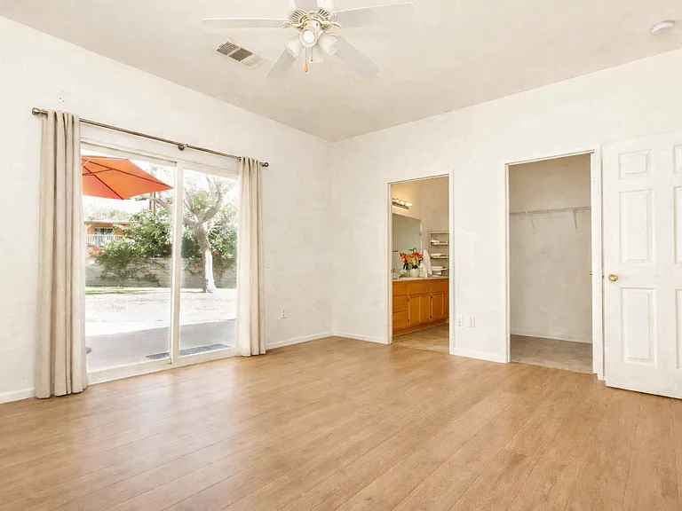 Virtual staged - showing what the wood like flooring could look like and curtains on the sliding door.