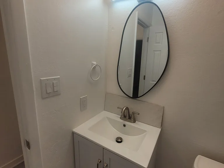 Bathroom with brand new vanity, mirror and light fixtures.
