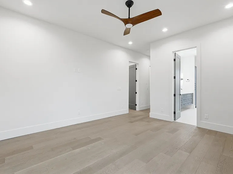 Spacious primary bedroom with modern finishes, recessed lighting, and ensuite access.