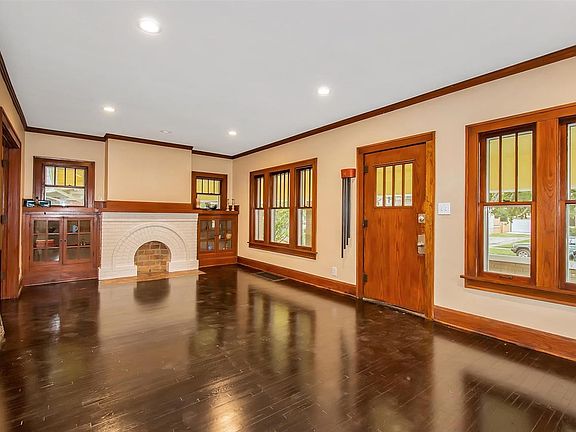 Curved fireplace, refinished hardwood, original non painted woodwork, bench at the end of the stairs, book cases on each side of the fireplace.  This living room is 26 x 15 and has everything you need & want in an older home.