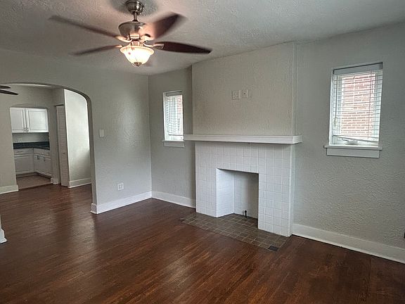 Spacious Living Room, decorative mantle, Ceiling fan, New windows, hardwood floors, large entrance to dining room