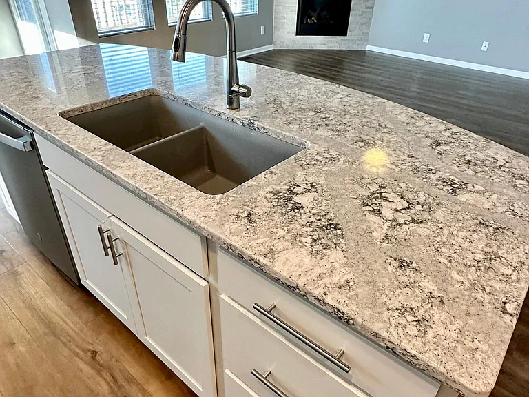 Quartz kitchen island with living room gas fireplace in background