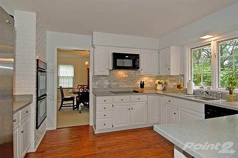 Remodeled Kitchen w/white cabinetry, corian, backsplash and undercabinet lighting