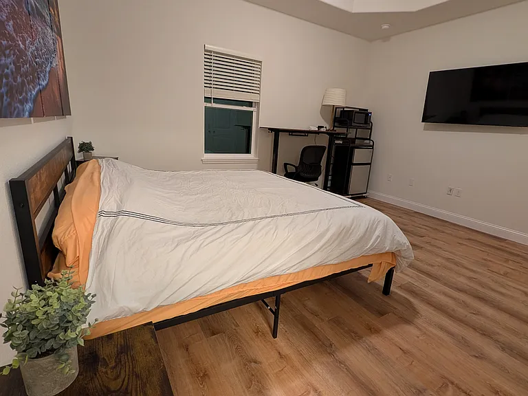 Master bedroom with king bed, desk, mini-fridge, and microwave. Also, not shown, access to large walk-in closet and private ensuite bath.
