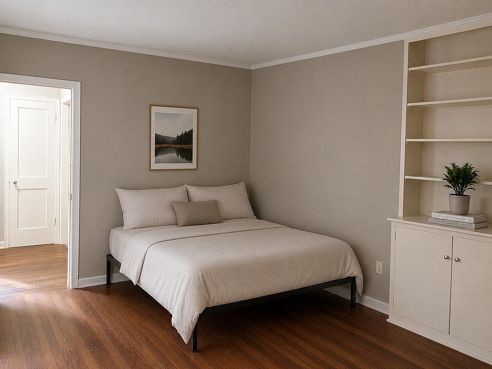 Furnished bedroom with hardwood floors, neutral walls, and built-in shelving plus cabinet storage for easy organization.