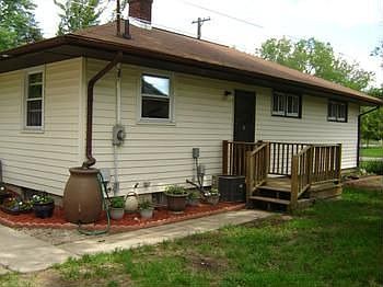 The fenced back yard has a great rain barrel on the corner of the house, and small back door deck.