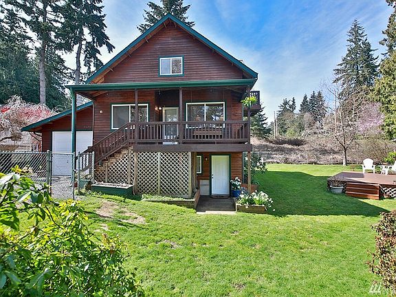 Front of home, view from Decatur Ave.  Single car garage w/laundry room attached. White door on lower level is entrance to great room. To the left of door (under porch) is an area that can be used for storage or as a dog kennel. 