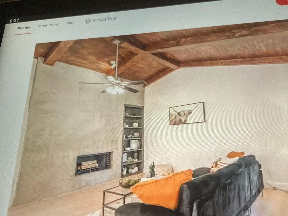 Spacious modern living room with vaulted ceiling and cozy wood burning fireplace.