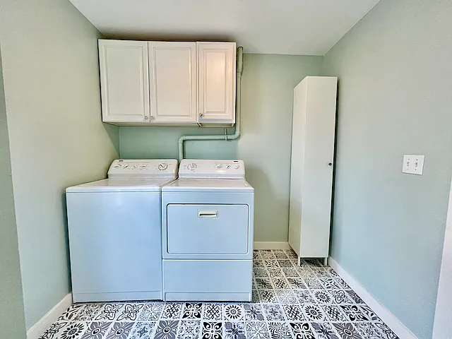 In unit laundry station with linen and storage cabinets.
