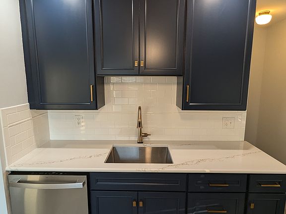 Newer cabinets and drawers with soft-close doors, Quartzite countertop, recessed lighting, ceiling fan, a deep stainless steel sink, and a touch-operated faucet.

(Note: The white line across the lower cabinets is just a glare from the lighting.)