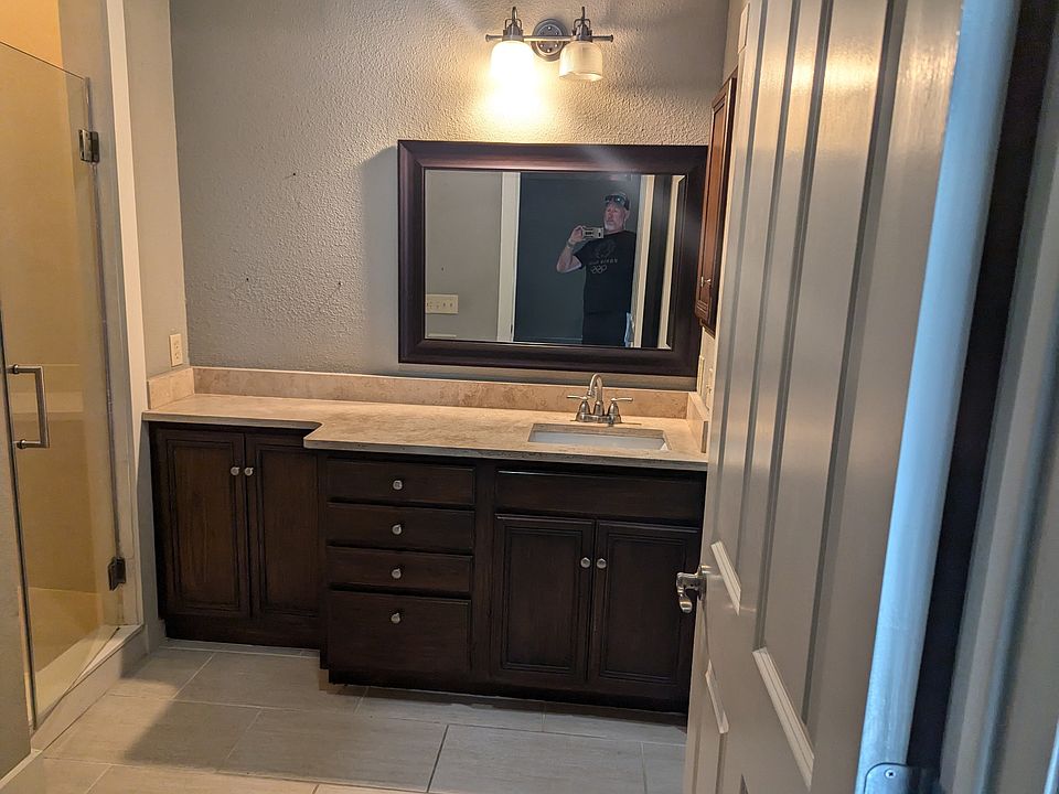 Main bath en suite. Over toilet cabinet, shower with glass door, medicine cabinet, extended counter space.