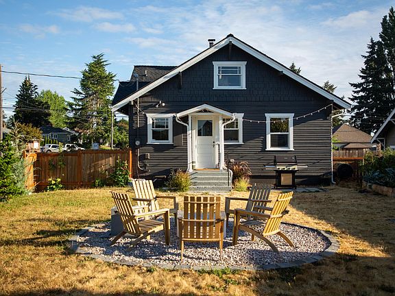 Backyard with fire pit, patio, BBQ area, and raised garden bed with fresh soil