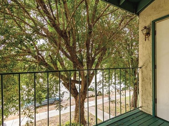Balcony is hugged by a beautiful tree for privacy and a refreshing view.
