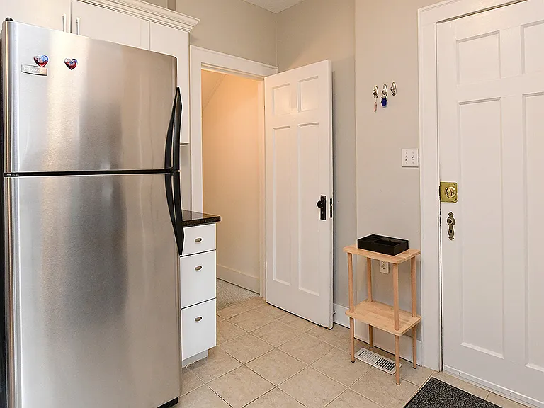 Kitchen. Fridge, entrance to basement bed room, and back entrance to parking area.