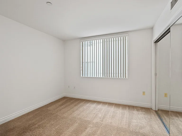 Bedroom with Window and Large-Size Mirrored Closet