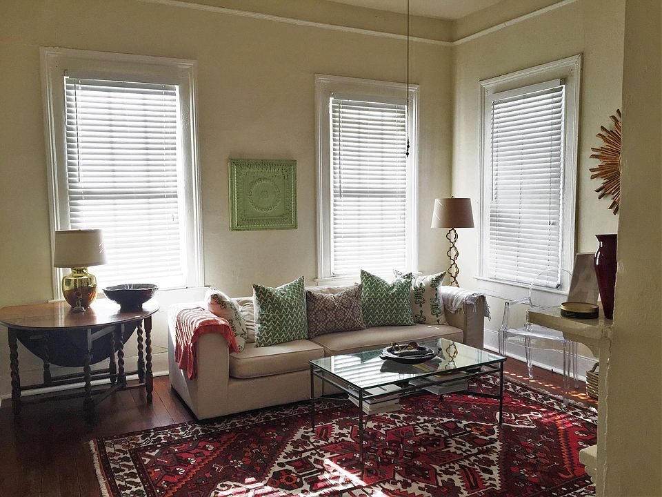 Living room has 4 large windows and a decorative fireplace (non-working) - unit does not come furnished