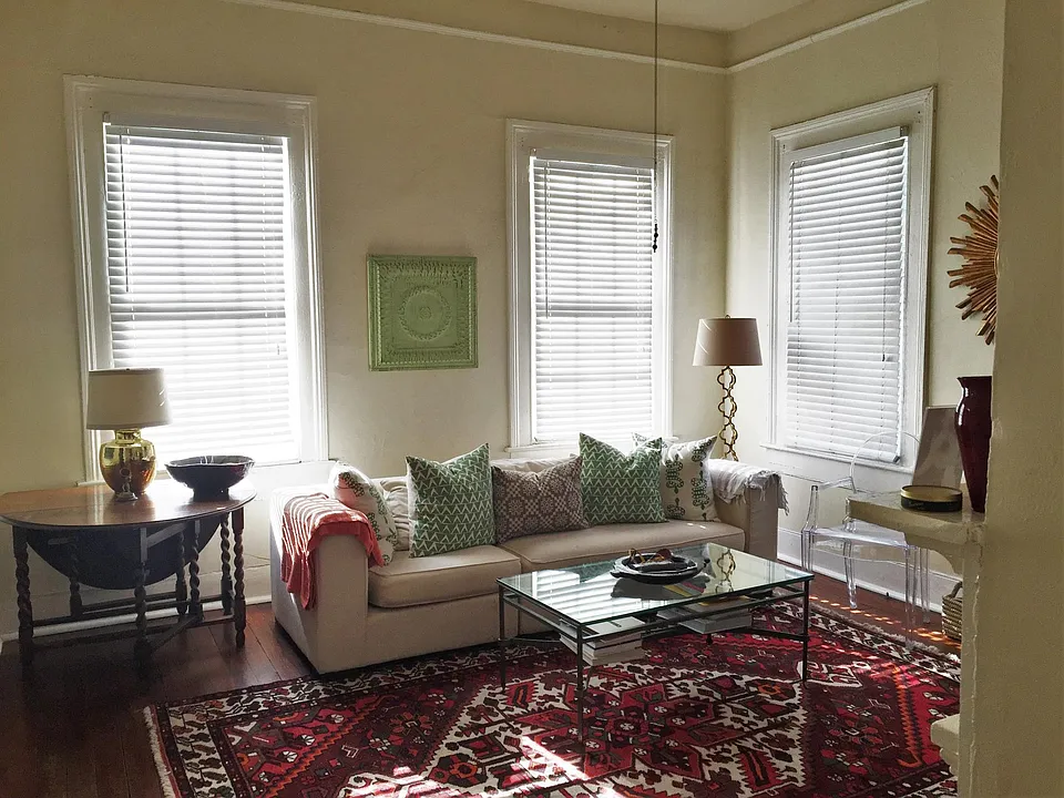 Living room has 4 large windows and a decorative fireplace (non-working) - unit does not come furnished