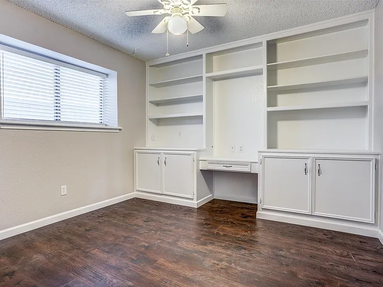 Third bedroom enjoys built in cabinets, desk and storage.