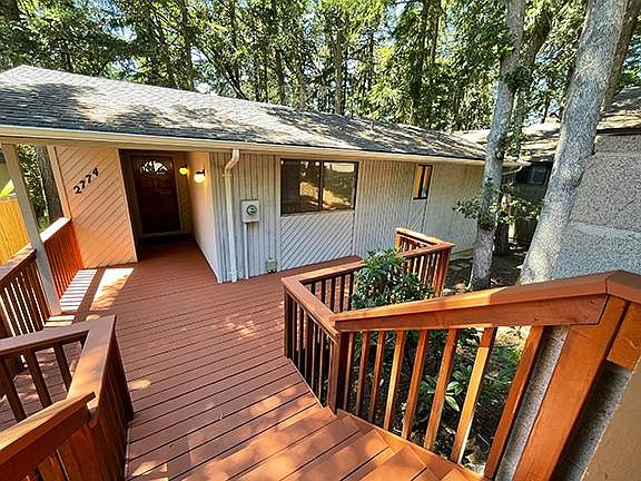 Front deck and entrance from the carport. An outdoor storage closet is to the left of the front door.