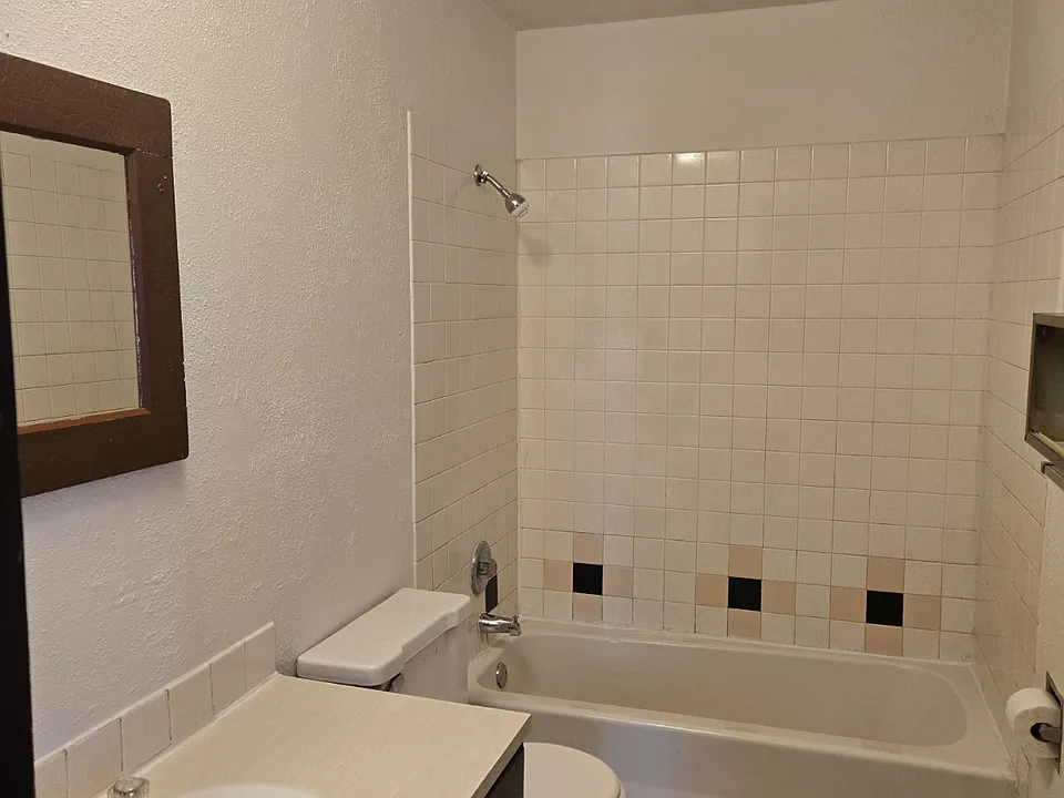 Freshly painted bathroom with unique tile flooring and bathroom surround.