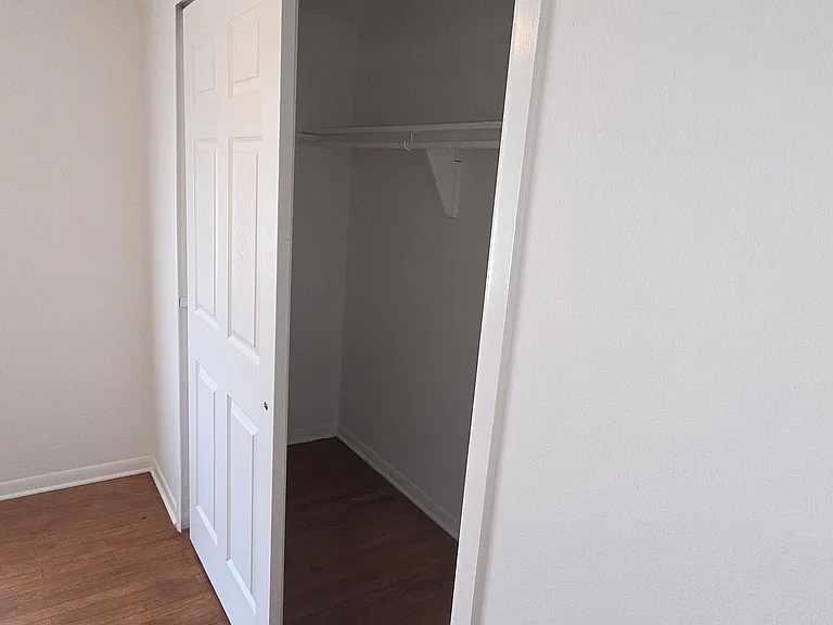 Wide primary-bedroom closet with shelf and hanging storage.
