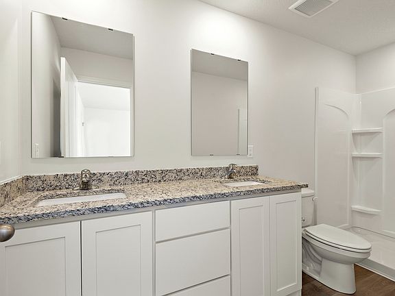 The master bathroom has a dual sink vanity and a step in shower.