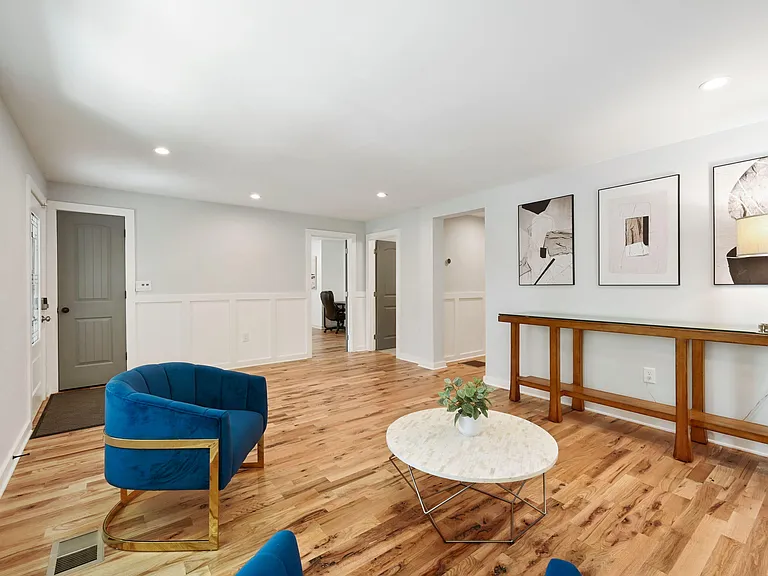Open living area with hardwood floors, recessed lighting, and a console wall ideal for shared lounging or a work zone.