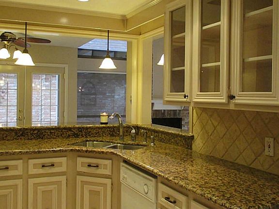 Cabinets galore and granite counter tops with tiled back splash makes this kitchen remarkable.
