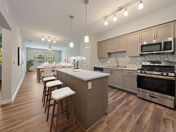 Kitchens are complete with quartz countertops and custom tile backsplash.